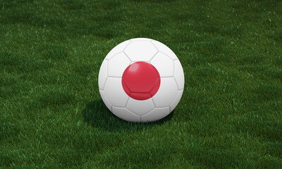 Soccer ball with Japan flag colors at a stadium on green grasses background.