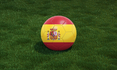 Soccer ball with Spain flag colors at a stadium on green grasses background.