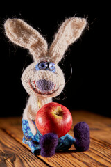 Funny homemade toy hare with red apple