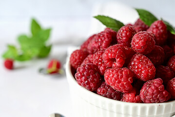 Juicy ripe raspberries in a plate on a white backgroundripe raspberries in a white plate on a white background, vitamins for the body