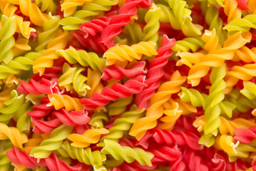 Close-up background of Fusille and Rotini in a glass bowl on white. pasta colorata	