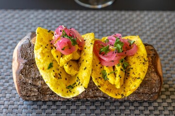 Two Mexican tacos with meat and vegetables in yellow corn tortilla with exclusive decoration