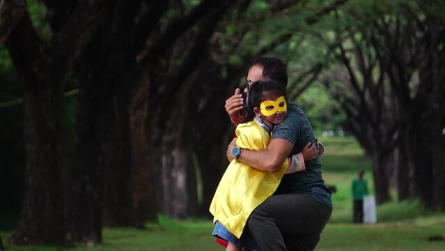 The children were happily playing with their father in the park