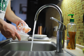 Man washing dish in sink at restaurant.People are washing the dishes too Cleaning solution
