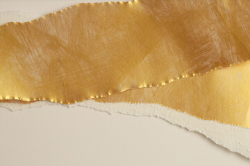 Gold torn empty pieces of texture paper on light beige copy space background.