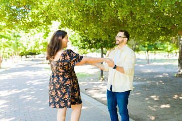 Fun boyfriend and girlfriend dancing outdoors