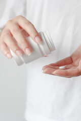 Close up of female hands pouring medicine tablets from bottle into her hand