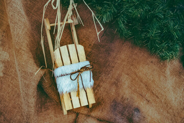 small wooden sleigh decoration in front of a wooden wall for christmas