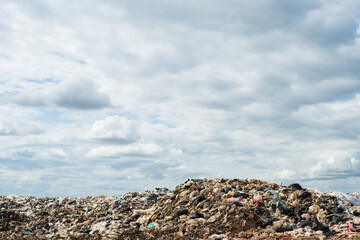 Aerial landfill on blue sky bakground.Garbage pile, waste plastic and other types of waste at the waste disposal site.Waste dumping site with save the earth and poor environment concept.