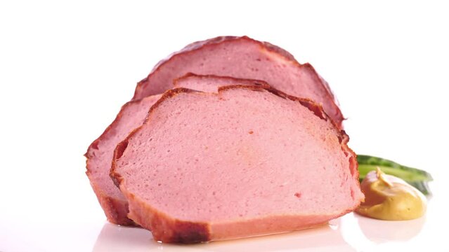 Baked Fine Meatloaf Slices - Fresh German Fleischkaese on a turntable isolated on white background