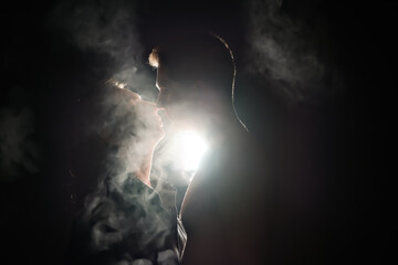 silhouette of a guy and a girl. men and women in the dark. smoke . steam . a man and a girl in a dark room are hugging. love concept.