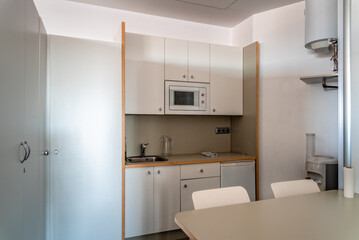 Fototapeta na wymiar Small kitchen for workers in co-working. Startup business office interior at new workplace. Open space office interior