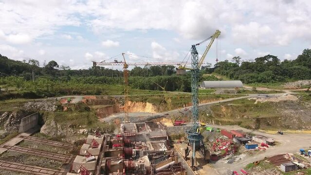 Aerial view. Flying between large construction cranes. Construction cranes on an industrial site. Equatorial Guinea, Africa.