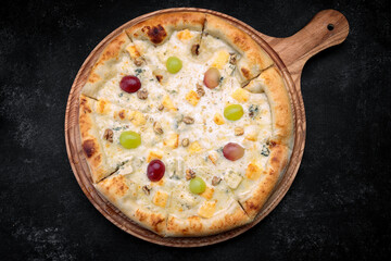 Pizza with pineapples, grapes, chicken and nuts