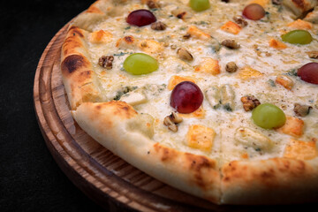 Pizza with pineapples, grapes, chicken and nuts