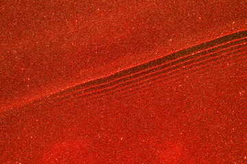 Abstract red sparkling background with glitters and ripples on the water surface, red shine texture