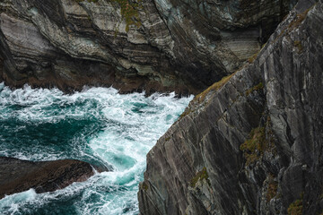 Kerry cliffs with green grass and dramatic clouds in cloudy autumn day, Kerry, Ireland.