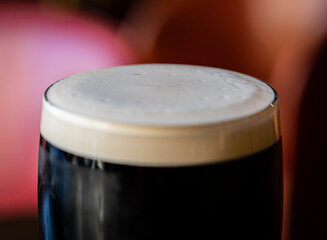 Closeup of foamy pint glass filled with porter