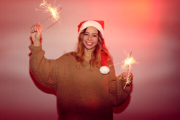 A woman in a Christmas hat with sparklers.