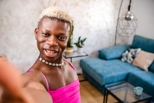 Joyful black transsexual woman showing her apartment to camera