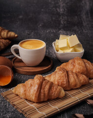 delicious croissants on parchment on a dark concrete background,coppy space.