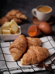 delicious croissants on parchment on a dark concrete background,coppy space.