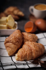 delicious croissants on parchment on a dark concrete background,coppy space.