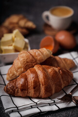 delicious croissants on parchment on a dark concrete background,coppy space.