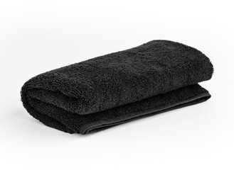 Black towel isolated on white background. Black color folded hand towel.