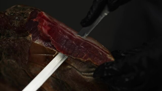 Chef cutting dry-cured spanish ham Jamon.