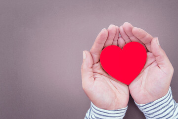 Obraz premium Man's hands holding red paper heart shape and Heart cardiogram, heart health, donation, happy volunteer charity, CSR responsibility, world health day, world mental health day, wellbeing.