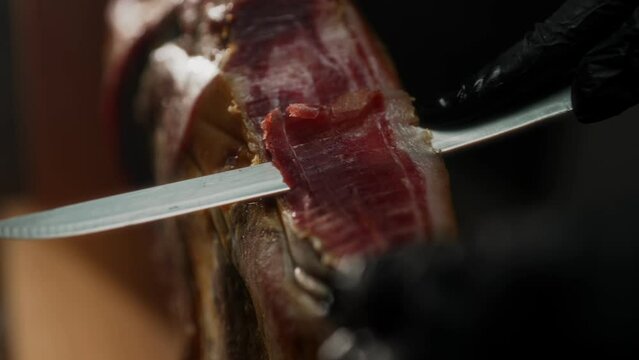 Chef cutting dry-cured spanish ham Jamon.