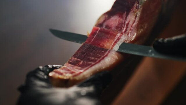 Chef cutting dry-cured spanish ham Jamon.