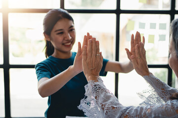 Group of Asian businesspeople raising their hands, rejoicing with the achievements as set forth,...
