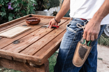 caucasian young man standing by the table preparing the gardening tools
