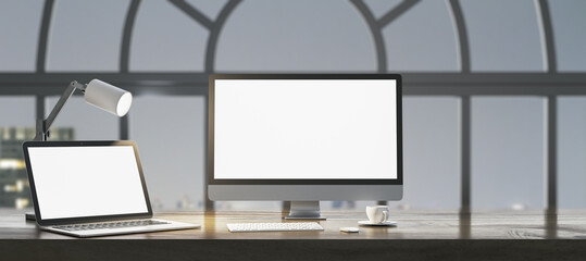 Fototapeta premium Close up of night designer workplace with empty white laptop computer screens, coffee cup and keyboard on wooden desktop and window with city view background. Mock up, 3D Rendering.