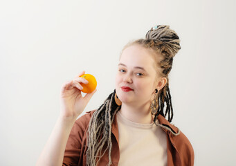 young woman with orange on white background