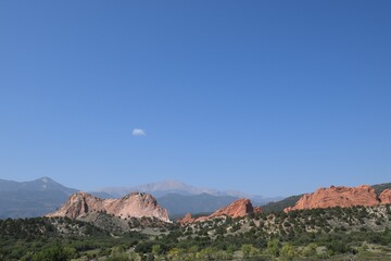 Naklejka premium Distant view of Garden of the Gods and Pikes Peak against clear blue sky with haze from California forest fires in the Colorado mountains