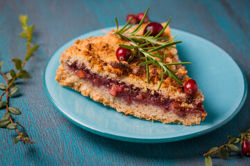 Delicious homemade grated pie with cranberries on a blue
