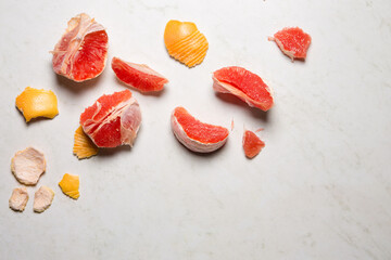Pieces of juicy grapefruit and peel on a light background