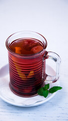 Pink fruit tea in a glass cup. Tea with fruits and herbs