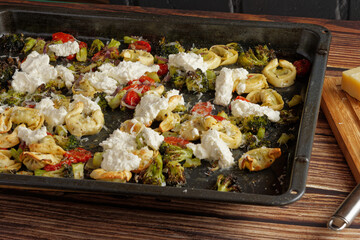 Tortellini with broccoli on a baking sheet with ricotta.