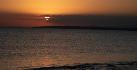 Sunrise in the sea with cloud stormy clouds and orange colour. Seascape at sunset. Sun rays in the ocean