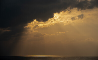 Sunrise in the sea with cloud stormy clouds and orange colour. Seascape in the morning. Sun rays in the ocean
