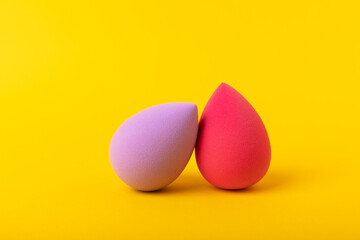 Beauty blender. Cosmetic sponge on a yellow background. MOCAP. Sponge for applying foundation and concealer. Beauty concept. Space for text. Space for copy space.