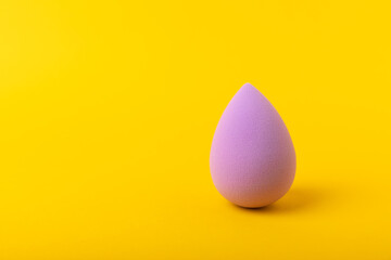 Beauty blender. Cosmetic sponge on a yellow background. MOCAP. Sponge for applying foundation and concealer. Beauty concept. Space for text. Space for copy space.