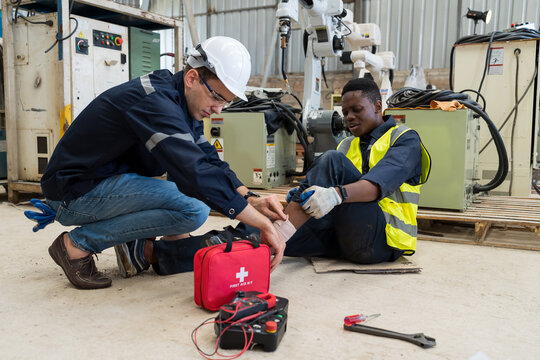 Male assistant first aid male worker accident with broken leg in the factory. Health insurance concept