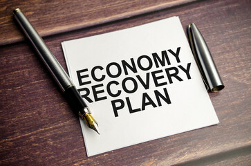 ECONOMY RECOVERY PLAN. Text on business card with pen