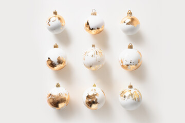 Christmas square composition made of white Christmas balls with gold leaf on white background. Flat...