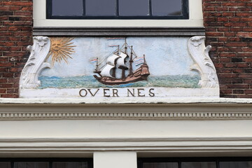 Sculpted Stone Tablet Depicting a Sailing Ship and a Sun on a House Facade in Amsterdam, Netherlands